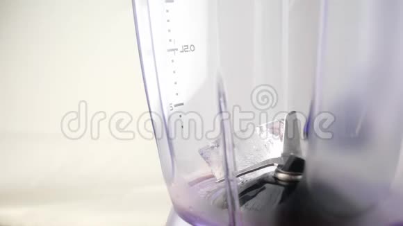 将榨汁机中的橙汁倒入白色背景的搅拌机中视频的预览图