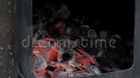 鲜红的热煤在火箱里燃烧铁炉的开门做饭或加热房间视频的预览图