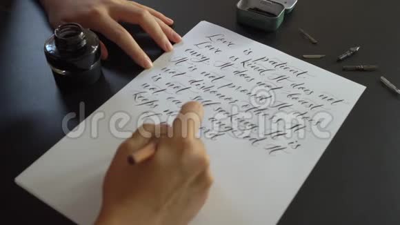 一位年轻女子用刻字技巧在纸上书写书法的特写镜头她写结婚誓言爱视频的预览图