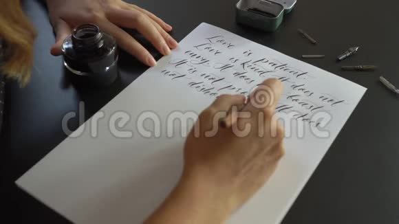 一位年轻女子用刻字技巧在纸上书写书法的特写镜头她写结婚誓言爱视频的预览图