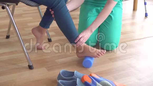 医生帮助一个轮椅上有矫形问题的十几岁女孩做健身运动以矫正双脚伸直视频的预览图