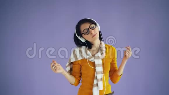无忧无虑的嬉皮士用耳机听音乐和跳舞的肖像视频的预览图