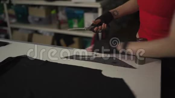 数码朋克时装设计师在她的工作室裁剪模式白种人白色妇女穿红色T恤和黑色视频的预览图