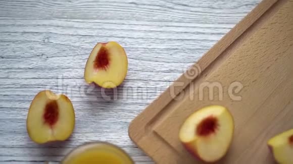 木桌上放着果汁的杯子上面放着桃子片和厨房的木板视频的预览图