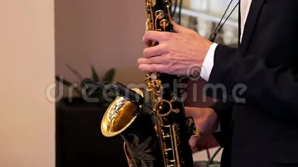 燕尾服萨克斯管演奏者用萨克斯管演奏音乐音乐家在音乐会上演奏萨克斯管爵士之夜现场秀视频的预览图
