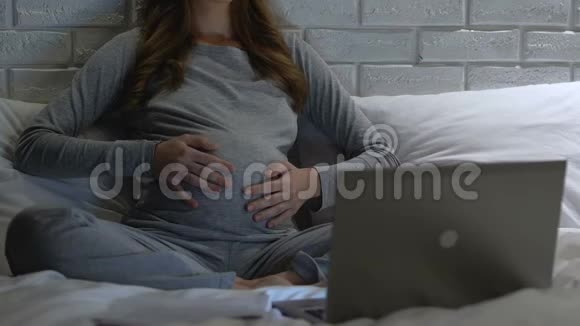 孕妇给肚子戴上耳机宝宝发育做母亲视频的预览图