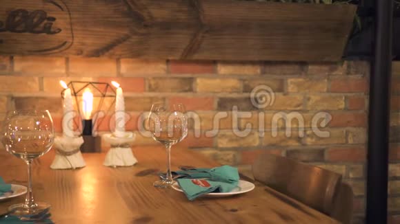 英俊的男人坐在桌子上点燃蜡烛做浪漫的晚餐年轻男子端着蜡烛等着女人视频的预览图