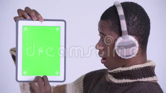 年轻快乐的非洲男人展示数字平板电脑的脸看上去惊讶地准备过冬视频的预览图