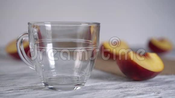 桃子汁倒在木桌上的玻璃杯子里上面有桃子切片视频的预览图
