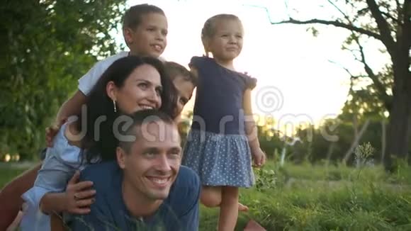 有三个孩子的大家庭在农村的草地上玩得很开心快乐的家庭假期视频的预览图