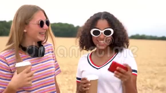金发女孩和混血青少年在社交媒体上喝咖啡在智能手机上自拍视频的预览图