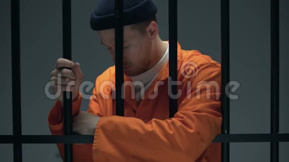 绝望的被囚禁的男性靠在酒吧里感到沮丧心理帮助视频的预览图