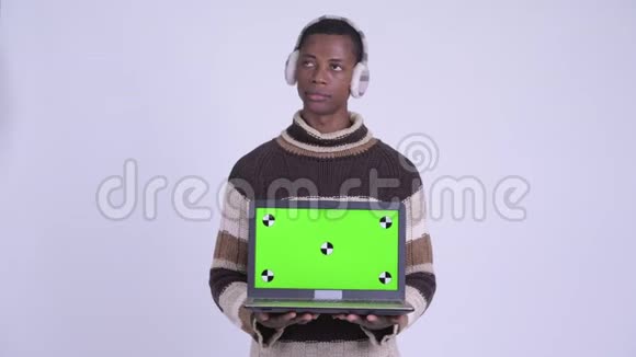 年轻快乐的非洲男人一边思考一边展示准备过冬的笔记本电脑视频的预览图