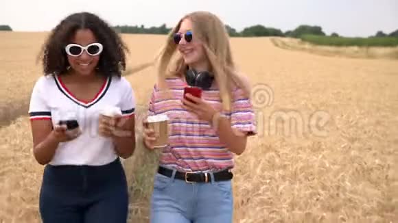 金发女孩和混血青少年在社交媒体上喝咖啡在智能手机上自拍视频的预览图