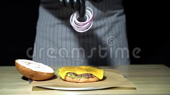 厨师准备汉堡把男人扔环洋葱的手举起来做汉堡包慢动作视频的预览图