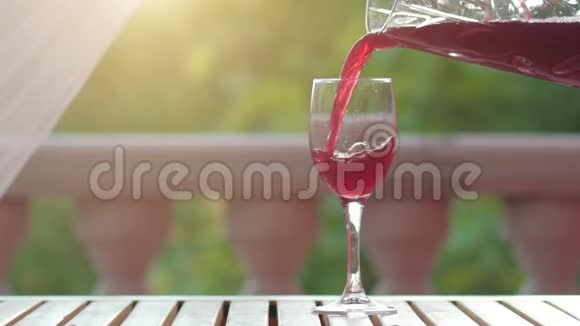 绿色自然背景下的自制葡萄酒倒入酒杯视频的预览图