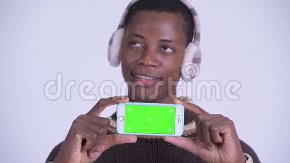 年轻快乐的非洲男人的脸在为冬天准备手机时思考视频的预览图