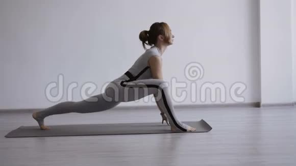 运动的漂亮女人在室内练习瑜伽视频的预览图