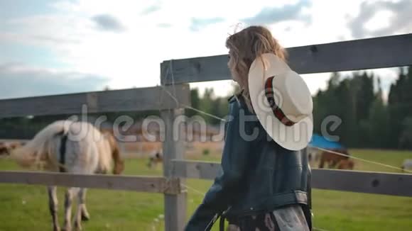 女人带着马走在围栏附近视频的预览图
