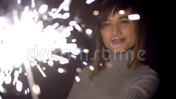 白种人的女孩带着微笑庆祝新年举着一个闪闪发光的家伙视频的预览图