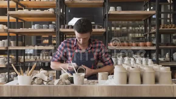 白种人男性陶工在花瓶上制作图案视频的预览图
