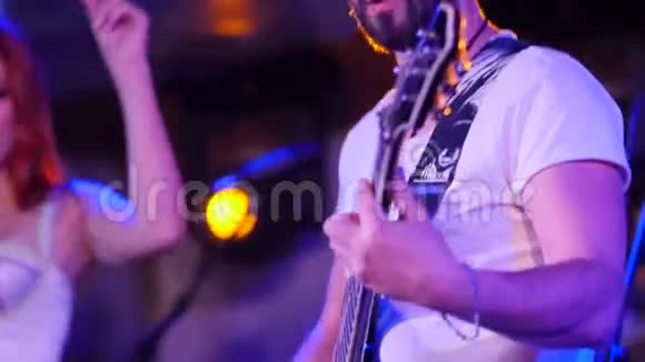 吉他手和歌手在背景上跳舞的特写镜头视频的预览图