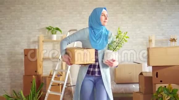 一位戴着头巾手里拿着一朵花和一个盒子的年轻穆斯林妇女的肖像视频的预览图