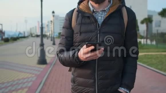 秋日城里人正在步行手里拿着智能手机视频的预览图