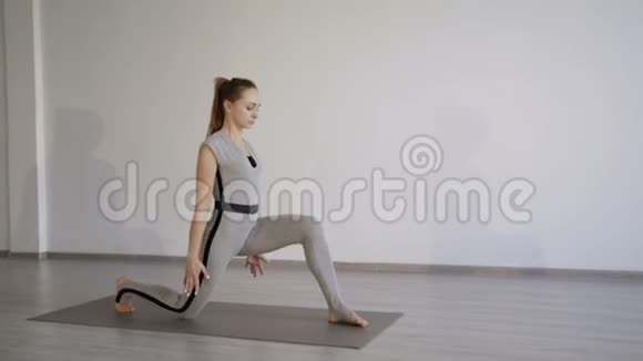 迷人的运动女孩训练腿伸展在一个平静舒适的工作室4K视频的预览图