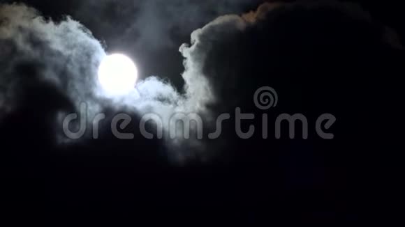 满月在夜空中的云彩中升起在夜晚的月光下观看在夜晚的流逝视频的预览图