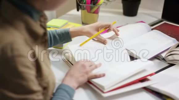 年轻女学生用书做家庭作业视频的预览图