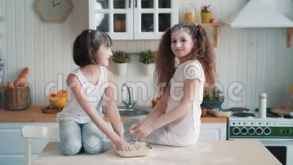 可爱的姐妹们互相扔面粉在厨房玩得开心动作慢视频的预览图