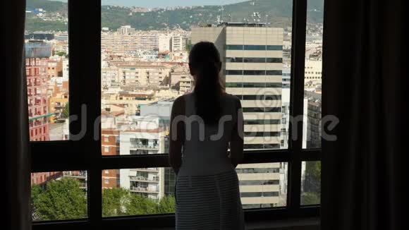 从窗外看巴塞罗那城市景观的女人视频的预览图