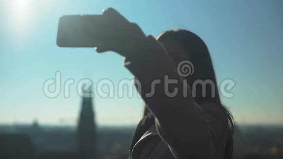 美丽的年轻女旅行者在天空甲板上自拍古城景色视频的预览图