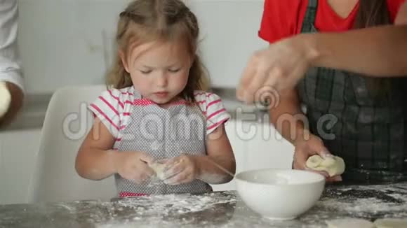 年轻的父母正在学习他们的女儿做饭他们展示了所有的烹饪过程视频的预览图