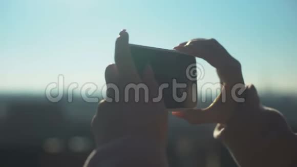 年轻的女性旅行者在智能手机旅游上拍摄老城区的照片视频的预览图