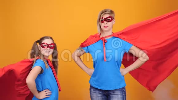 带着超级英雄斗篷和面具和妈妈在一起的快乐少女视频的预览图