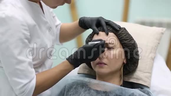 美容医生给她的女客户做面部美容注射美丽的女性面容和美容师双手视频的预览图