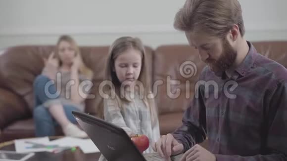有胡子的人用平板电脑特写的肖像小女孩试图给男人苹果但没有成功视频的预览图