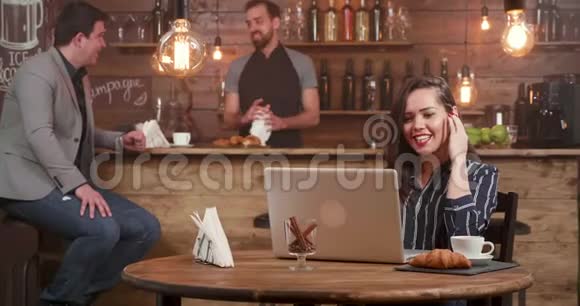 可爱的女人用耳机在餐馆说话视频的预览图