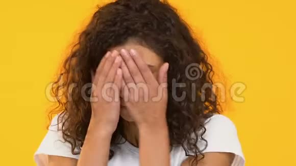 恐惧的双种族女孩藏在手中恐惧情绪恐惧症视频的预览图
