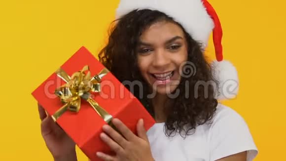 圣诞老人帽子里的棕色头发带着礼物跳舞圣诞节前大减价视频的预览图