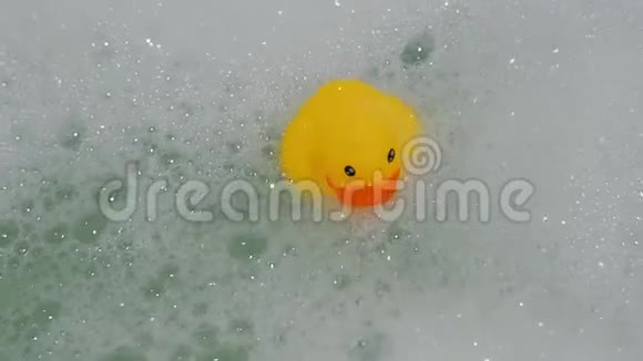 橡皮黄鸭玩具用泡沫在浴缸中漂浮视频的预览图