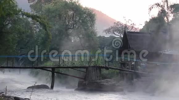 美丽的风景清新的河水缓缓流过天然的岩滩清晨弥漫着蒸汽和竹子视频的预览图