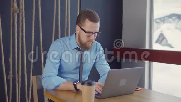 男人在当代的办公室里工作在冬日里用笔记本电脑打字视频的预览图