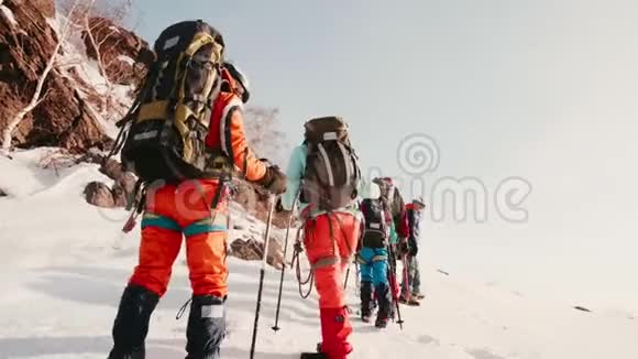 救援人员在大雪中徒步爬雪车一个接一个他们绕着山走帮助视频的预览图