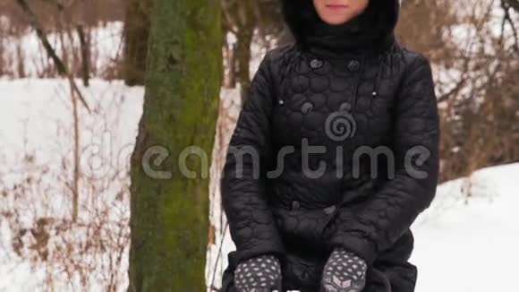 特写镜头慢镜头美丽的女人在森林里的冬天骑着秋千视频的预览图