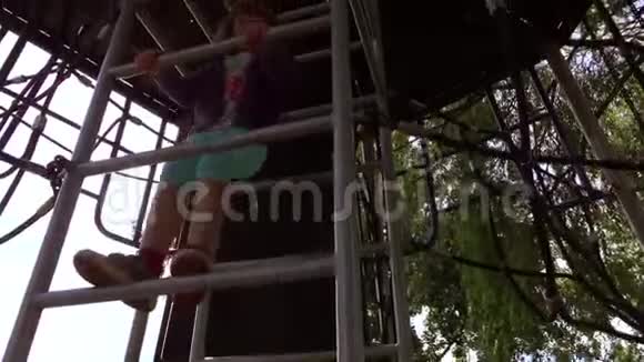 女孩爬上操场上的梯子视频的预览图