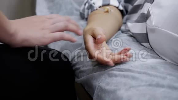 在临床病房妇女支持用导管握住双手进行治疗双手特写视频的预览图