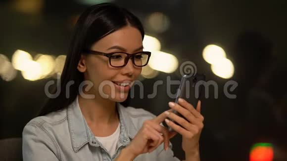 亚洲女人在手机上滚动照片在社交网络上交流视频的预览图